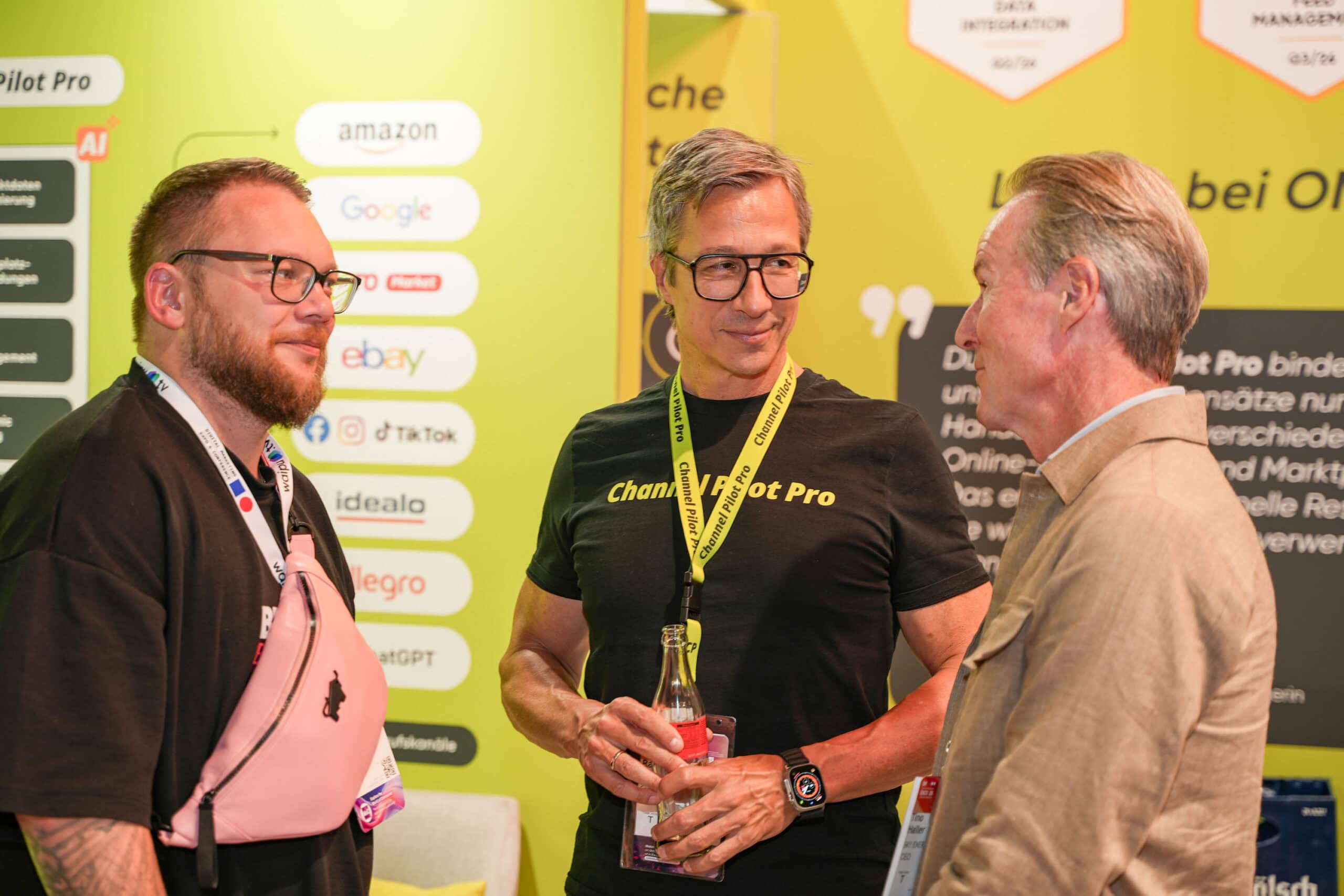 Drei Männer im Gespräch bei einer Fachmesse, Channel Pilot Solutions Stand.